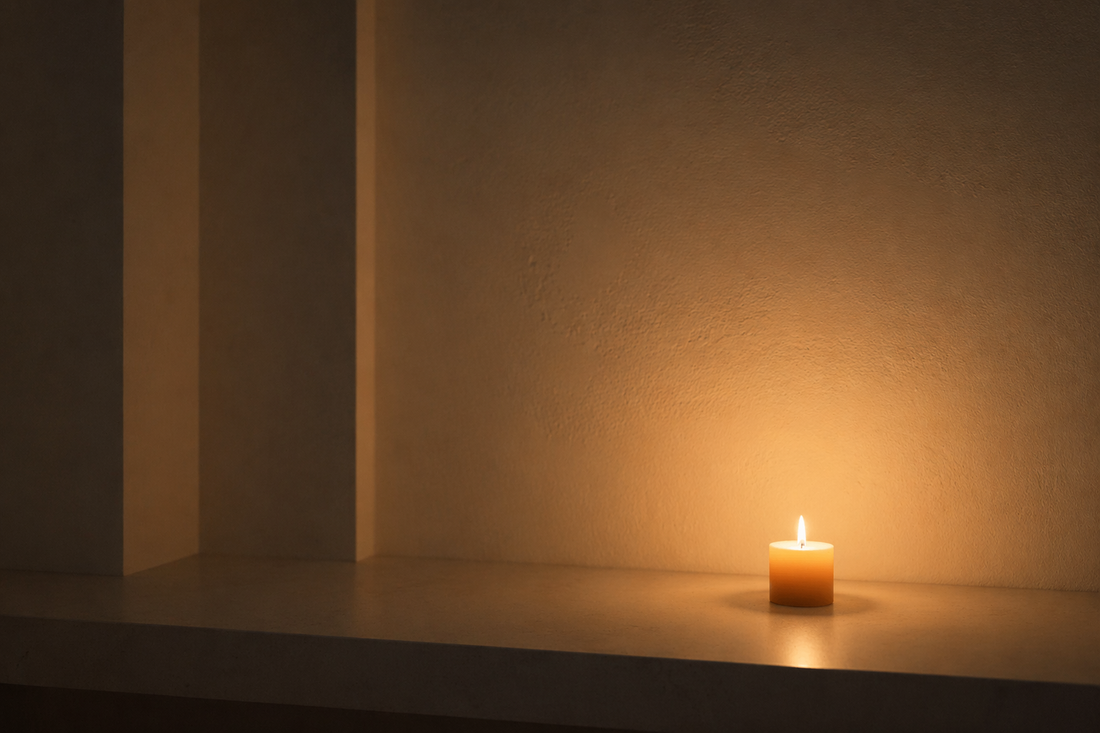 Neutral surface with a candle placed off-center creating a soft ambient glow.
