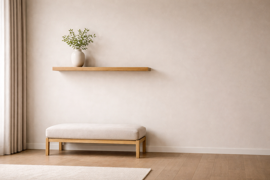  Minimal wall with a single floating shelf and one object above a bench, creating clear vertical balance and visual weight distribution.