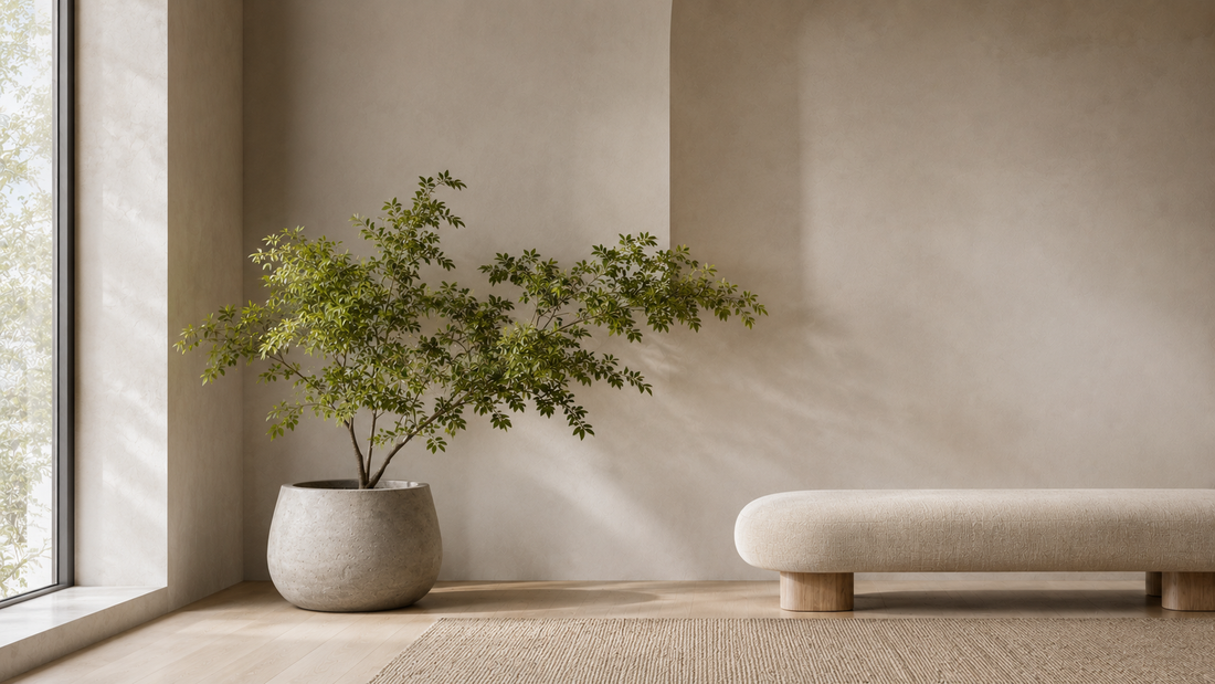 Faux greenery with layered organic foliage reducing visual tension in a minimal interior.