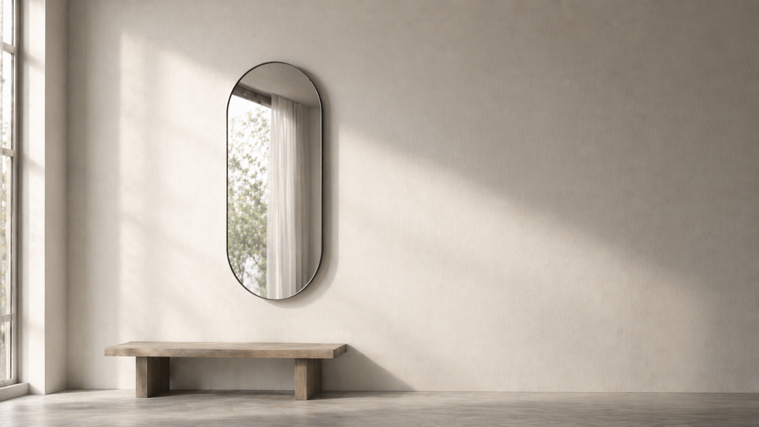 Minimal room with a wall-mounted mirror reflecting soft indirect light, creating balanced depth and clear spatial structure.