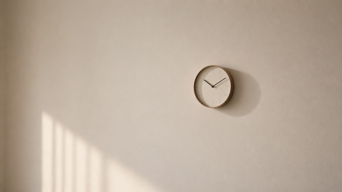 Minimal wall with a small clock subtly shifting visual balance through negative space and soft shadow.